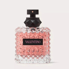 Valentino perfume bottle with pink and black design on a light gray background