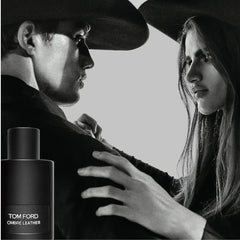 Black and white image of a couple embracing with a Tom Ford Ombré Leather bottle.
